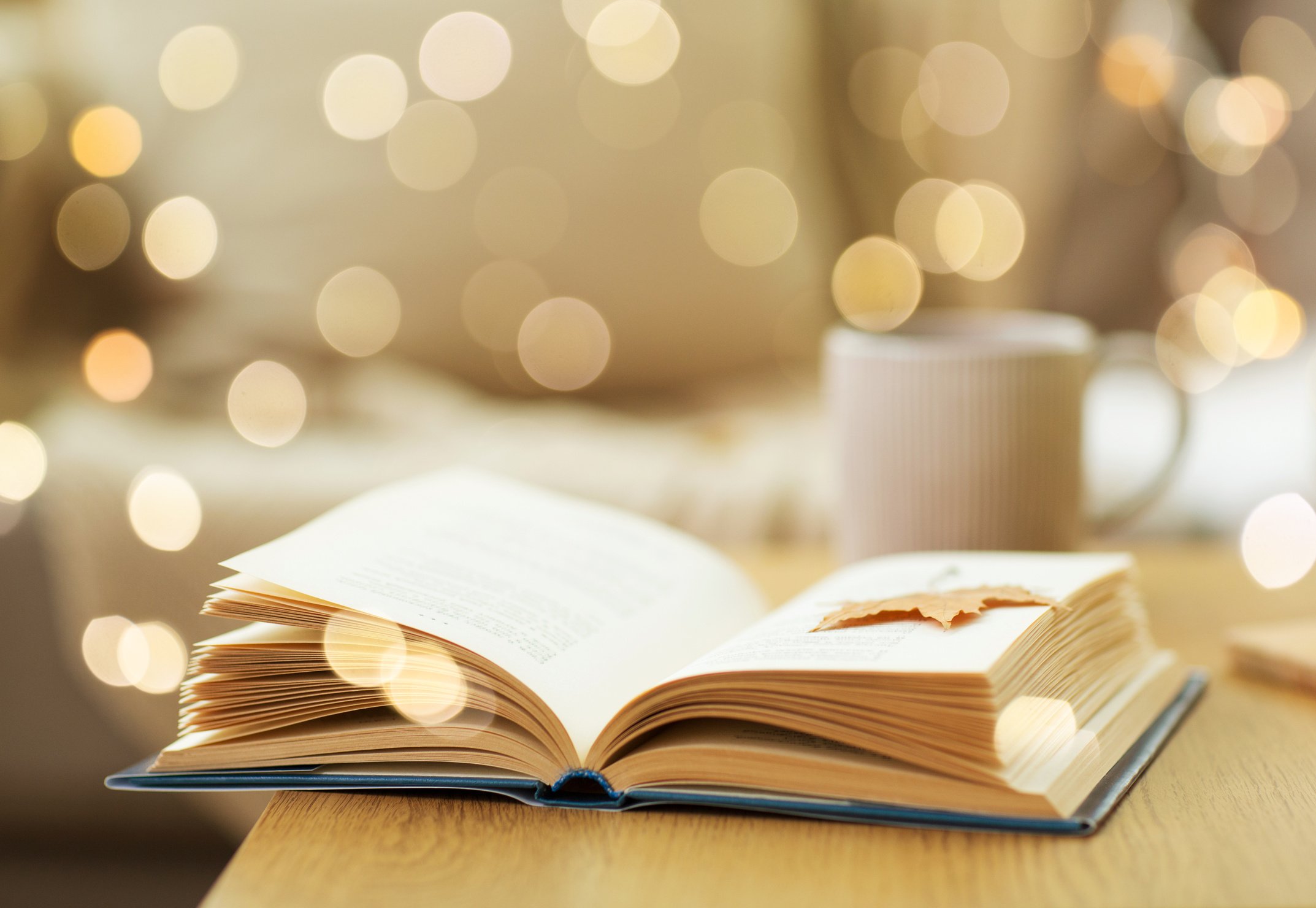 Book with Autumn Leaf on Wooden Table at Home